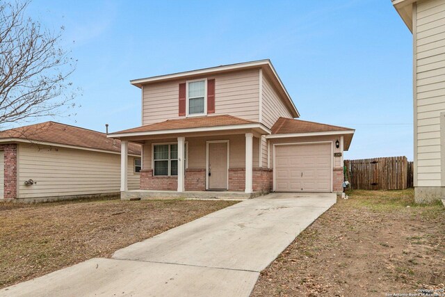 traditional home with a porch, an attached garage, brick siding, fence, and driveway