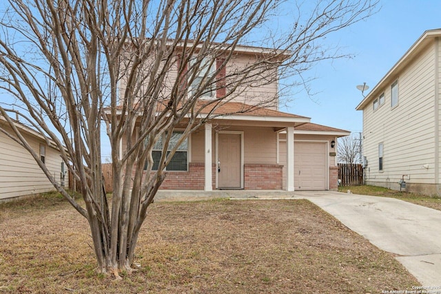 traditional-style house with a garage, driveway, brick siding, and fence