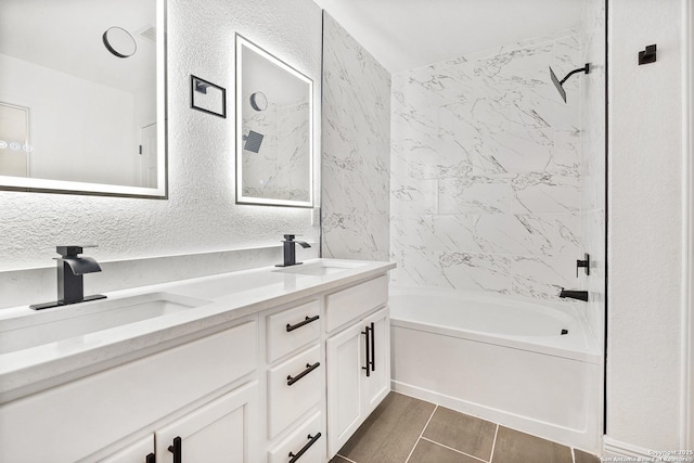 bathroom featuring tiled shower / bath and vanity