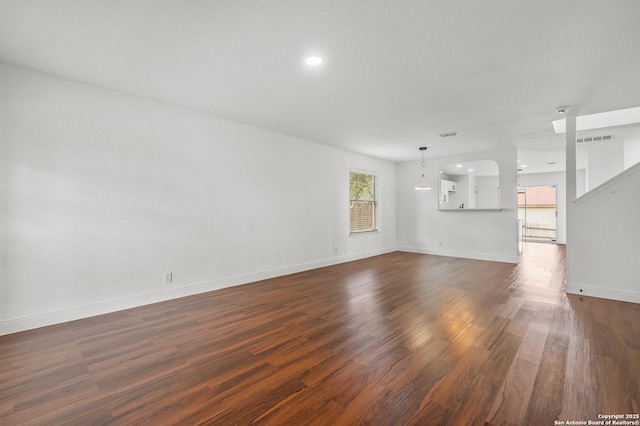 unfurnished living room featuring dark hardwood / wood-style floors