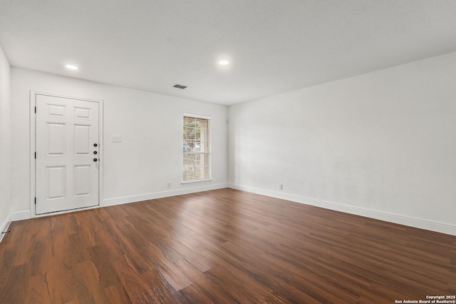 empty room with dark hardwood / wood-style flooring