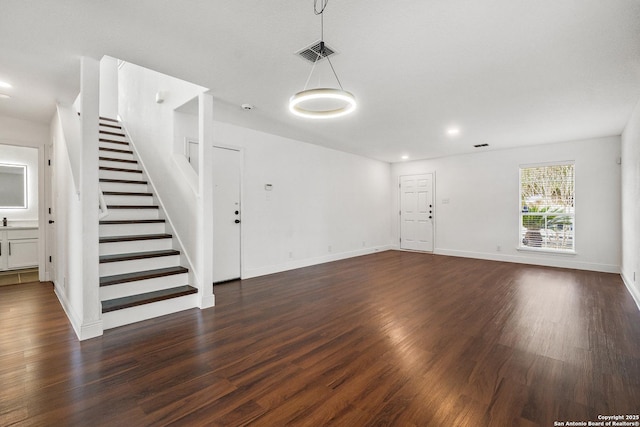 unfurnished living room with dark wood-type flooring