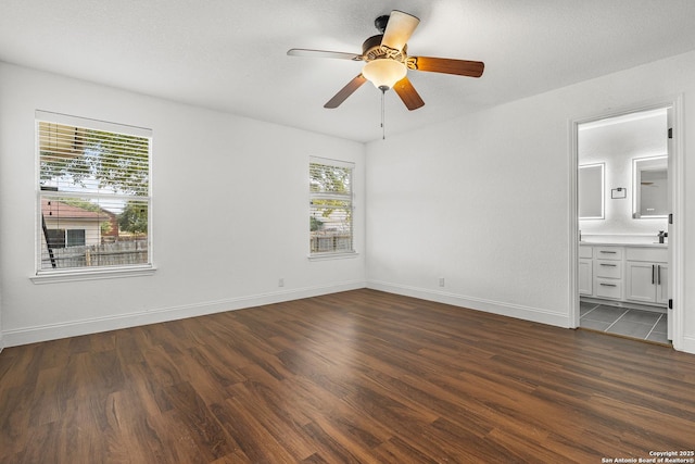 unfurnished bedroom with dark hardwood / wood-style floors, connected bathroom, a textured ceiling, and ceiling fan