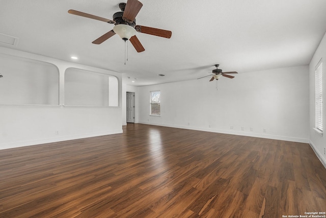 unfurnished living room featuring ceiling fan and dark hardwood / wood-style flooring