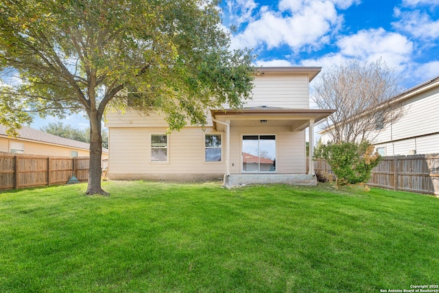 rear view of property featuring a lawn