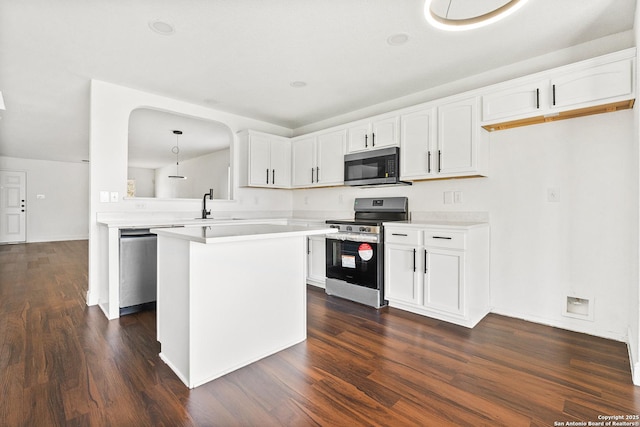 kitchen with white cabinetry, hanging light fixtures, dark hardwood / wood-style flooring, and appliances with stainless steel finishes