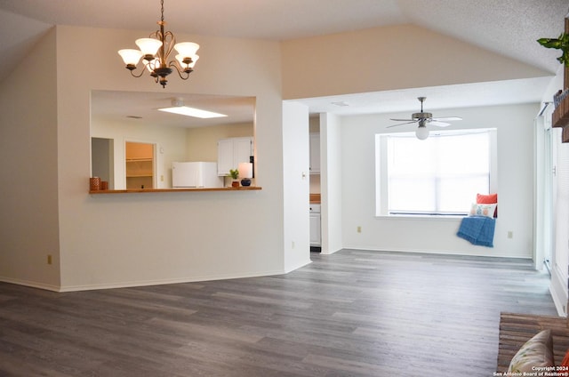 unfurnished living room with ceiling fan with notable chandelier, vaulted ceiling, and dark hardwood / wood-style floors