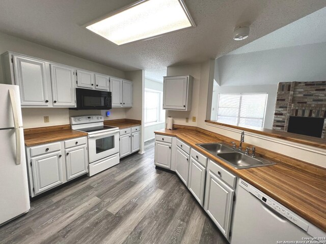 kitchen featuring sink, white appliances, white cabinets, and wood counters