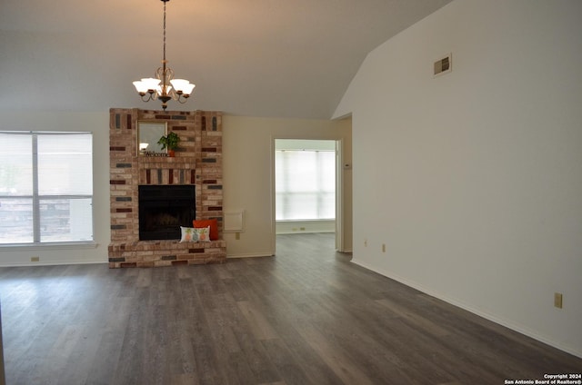 unfurnished living room featuring lofted ceiling, dark wood-type flooring, a fireplace, and plenty of natural light