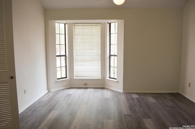 unfurnished room with dark hardwood / wood-style floors