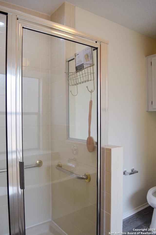 bathroom featuring a shower with door and a textured ceiling