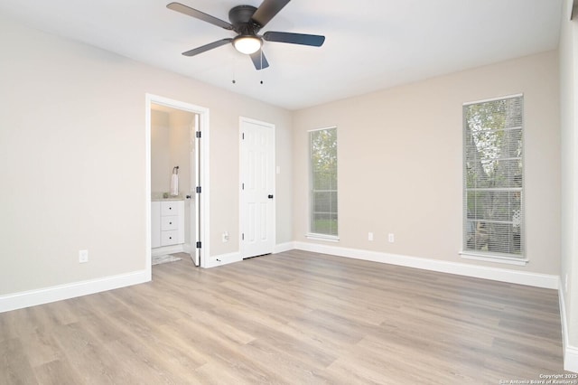 unfurnished bedroom with multiple windows, ceiling fan, connected bathroom, and light hardwood / wood-style floors