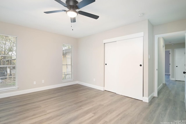 unfurnished bedroom featuring ceiling fan, a closet, and light hardwood / wood-style flooring