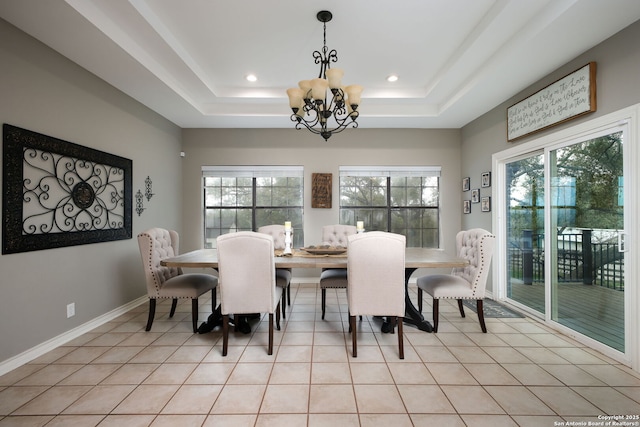 dining room featuring light tile patterned floors, a chandelier, and a tray ceiling