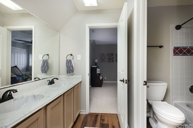 full bathroom featuring vanity, toilet, tiled shower / bath combo, and hardwood / wood-style floors