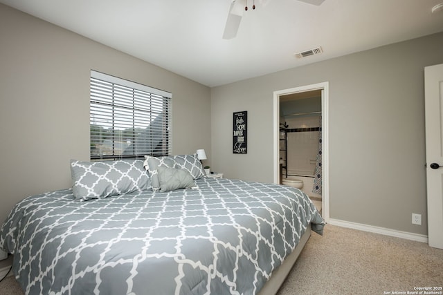 bedroom with ceiling fan, ensuite bath, and light carpet