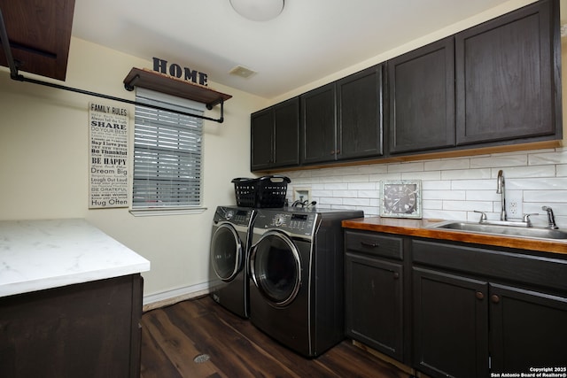 laundry room with dark hardwood / wood-style flooring, sink, cabinets, and independent washer and dryer