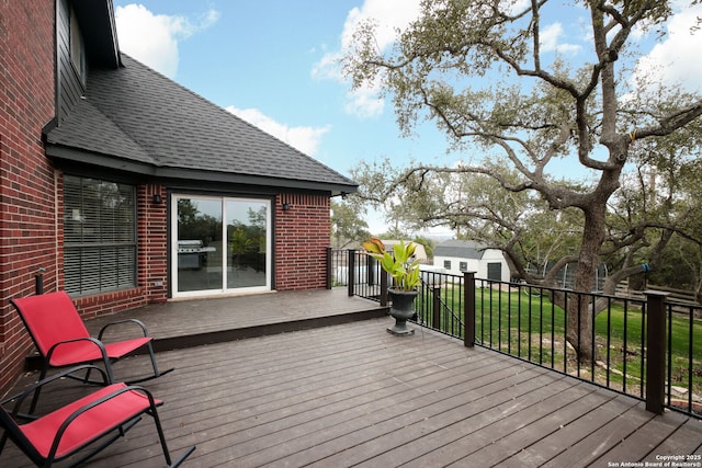 wooden terrace with a storage unit and a yard