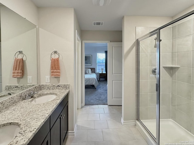 bathroom featuring vanity, a shower with shower door, and tile patterned floors