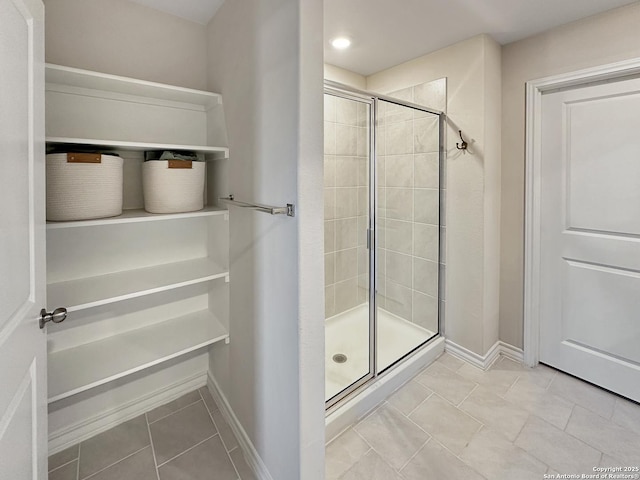 bathroom with a shower with shower door and tile patterned flooring