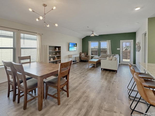 dining room featuring vaulted ceiling, ceiling fan, and light wood-type flooring