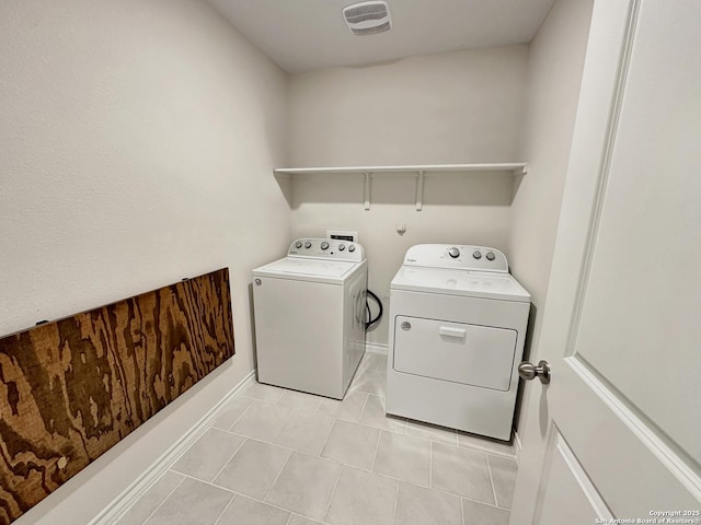 laundry area with light tile patterned floors and washer and clothes dryer