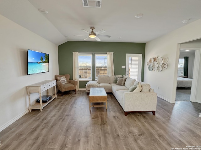 living room featuring vaulted ceiling, ceiling fan, and light hardwood / wood-style flooring