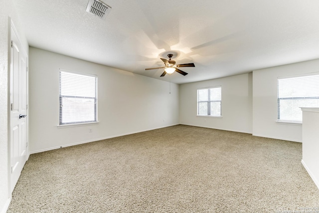 unfurnished room with ceiling fan and a textured ceiling