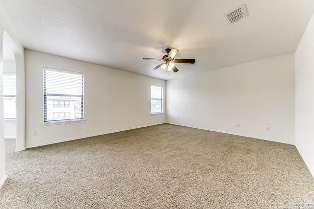 carpeted spare room with ceiling fan and a textured ceiling