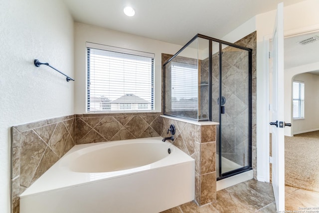 bathroom with plenty of natural light and independent shower and bath