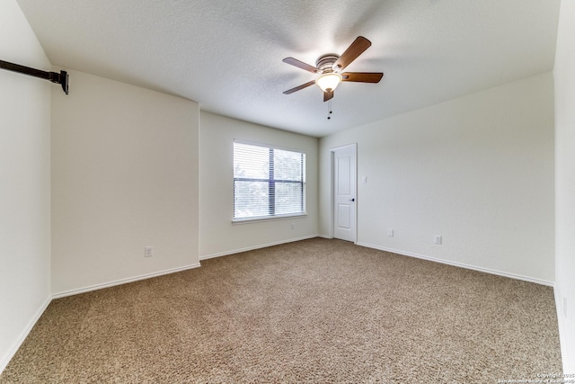 spare room with a barn door, carpet floors, a textured ceiling, and ceiling fan