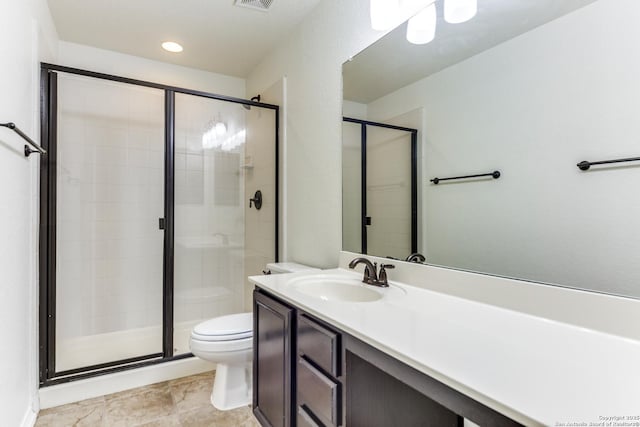 bathroom featuring vanity, toilet, and a shower with shower door