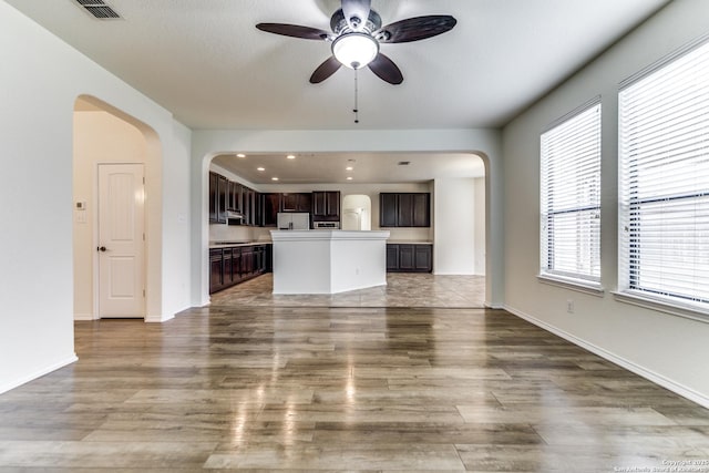 unfurnished living room with wood-type flooring and ceiling fan