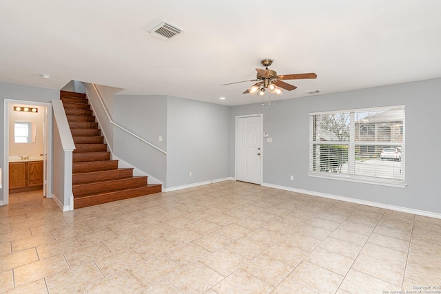 unfurnished living room featuring ceiling fan, sink, and light tile patterned floors