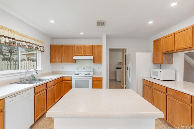 kitchen with white appliances, washer / clothes dryer, sink, and a kitchen island