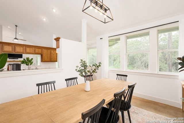 dining space featuring vaulted ceiling and plenty of natural light