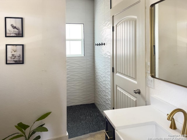 bathroom with vanity and a tile shower