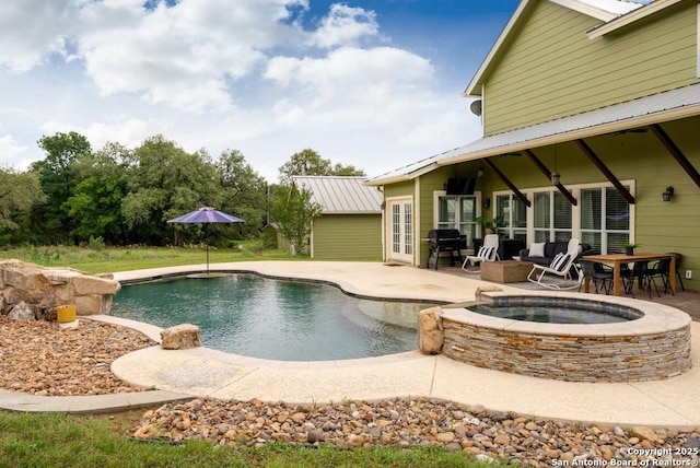 view of swimming pool with an in ground hot tub, area for grilling, and a patio area