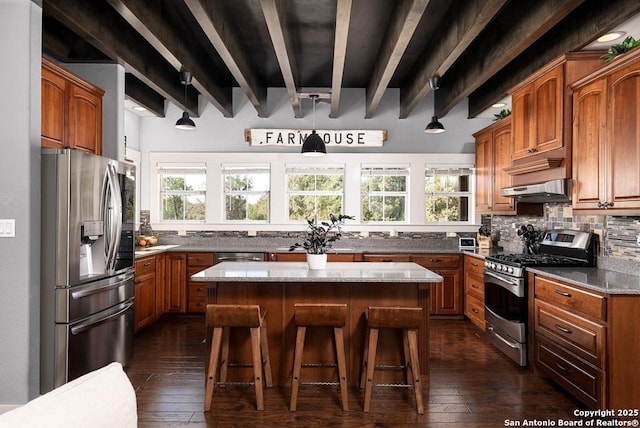 kitchen with a kitchen island, a breakfast bar, decorative backsplash, stainless steel appliances, and beam ceiling