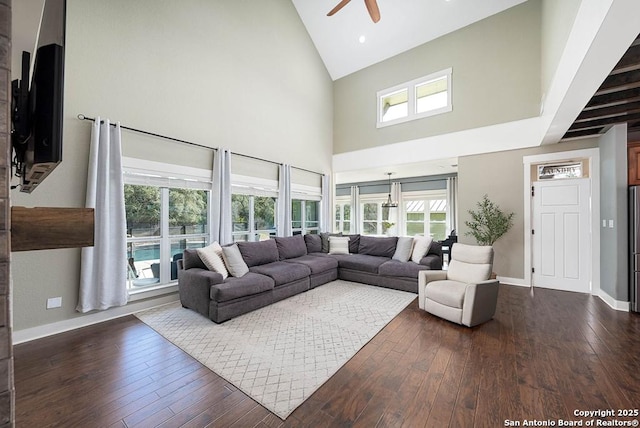 living room with ceiling fan, dark hardwood / wood-style floors, and high vaulted ceiling