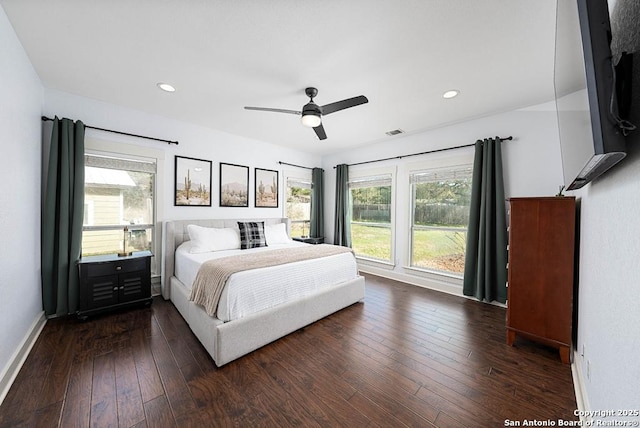 bedroom with multiple windows, dark wood-type flooring, and ceiling fan