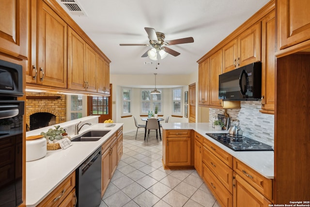 kitchen with black appliances, sink, hanging light fixtures, light tile patterned floors, and kitchen peninsula