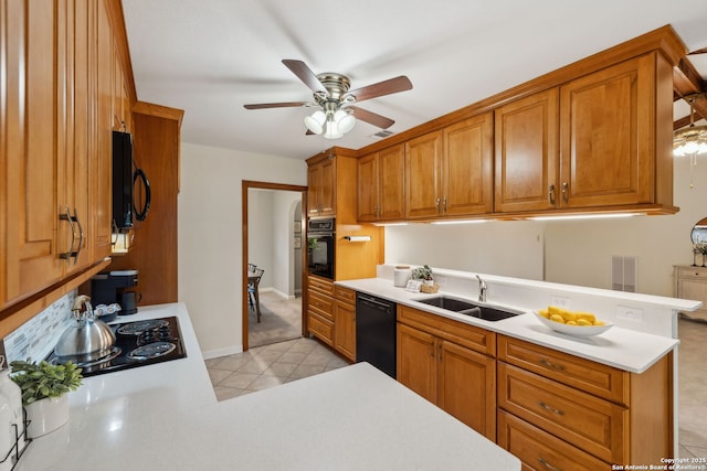 kitchen featuring sink, light tile patterned floors, black appliances, and kitchen peninsula