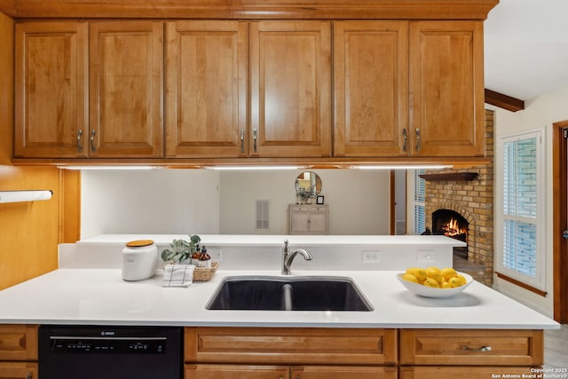 kitchen featuring beamed ceiling, a fireplace, black dishwasher, and sink