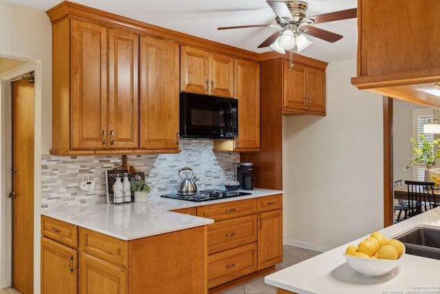 kitchen with tasteful backsplash, ceiling fan, light tile patterned flooring, and black appliances