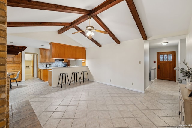 kitchen with lofted ceiling with beams, light tile patterned floors, decorative backsplash, and kitchen peninsula