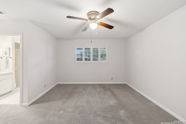 carpeted spare room featuring ceiling fan