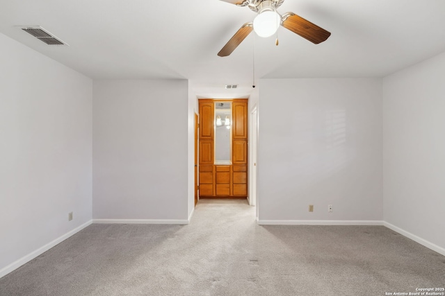 carpeted spare room with ceiling fan