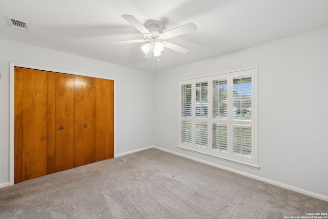 unfurnished bedroom with a closet, ceiling fan, and carpet flooring