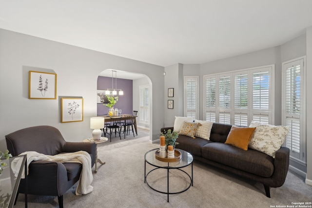 living room with light colored carpet and a chandelier